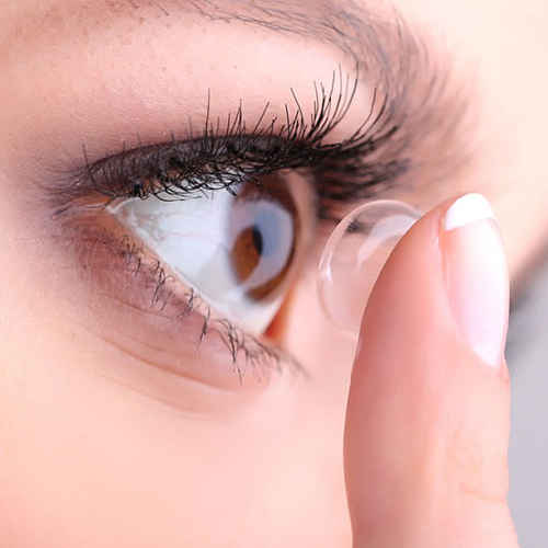 Contact lens fitting. Person inserting contact lens.